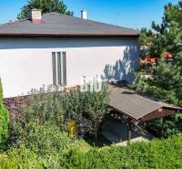 A Kamenna utcai családi házat Nitrán díszfák és zöld növényzet veszi körül.