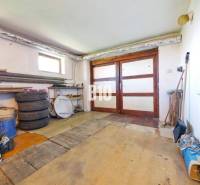 Garázs egy családi házban faajtókkal és fa dekorációhoz hasonló padlóval.