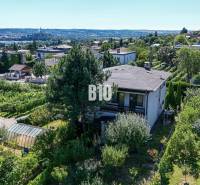 Kilátás a Kamenná utcai családi házra Nyitrán, zölddel és városi panorámával körülvéve.