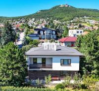 Családi ház a Nyitrai Kő utcában, zölddel és más házakkal körülvéve.