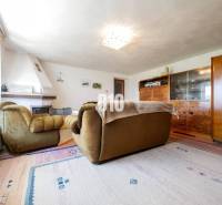 Nappali kandallóval és retro bútorokkal egy családi házban, fa dekoros padlóval.