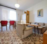 Nappali egy családi házban szőnyeggel és piros székekkel.