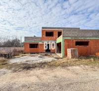 Befejezetlen téglából épült családi ház csendes környezetben, ideális a leendő tulajdonosok számára.