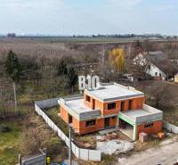 Építés alatt álló családi ház, kerttel körülvéve, vidéki kilátással a mezőkre.