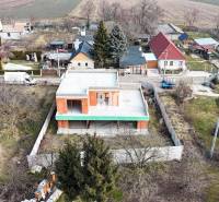 Családi ház építése garázzsal kellemes vidéki környezetben, családi házak között.