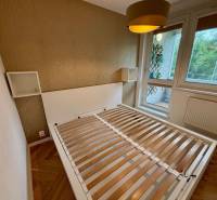 Hálószoba ággyal és nagy ablakkal, 2 szobás lakás fa dekor padlóval.