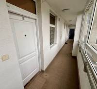 Folyosó egy kétszobás lakásban fehér ajtókkal és csempével.