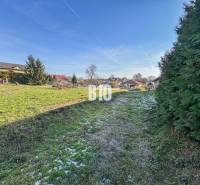 A képen egy zöld telek látható házakkal, amely lakhatásra alkalmas.