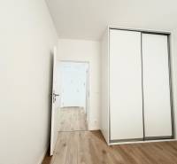 Szoba szekrénnyel és fa dekorációjú padlóval egy kétszobás lakásban.