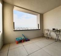 Erkély kilátással a városra, játékokkal és bútorokkal a 2 szobás lakásban.