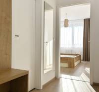 Folyosó egy 2 szobás lakásban, fa dekorációjú padlóval és tükörrel a falon.