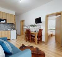 Nappali egy háromszobás lakásban, fa hatású padlóval és kényelmes ülőgarnitúrával.