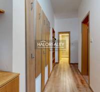 Folyosó egy 3 szobás lakásban fa dekor padlóval és fogasfallal.