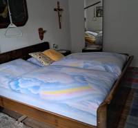 Hálószoba családi házban fa dekorációval, nagy tükörrel és fali dekorációkkal.