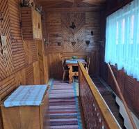 Családi ház belső tere fa dekorációjú padlóval és hagyományos fali dekorációkkal.