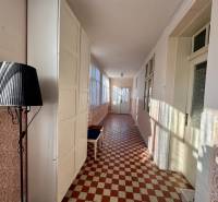 Folyosó egy családi házban mintás csempével és fekete lámpával.