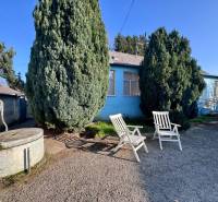 Családi ház Kunov utcában, Szenice, udvaron székekkel és kúttal.