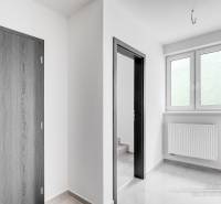 Családi ház belső tere fehér falakkal, fa dekorációjú műanyag ablakokkal és ajtókkal.