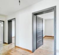 Családi ház belső tere fa dekorációjú padlóval és fehér falakkal.