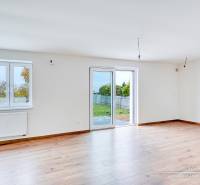 Világos szoba fa dekorációs padlóval családi házban, nagy ablakokkal, teraszra való kijárattal.