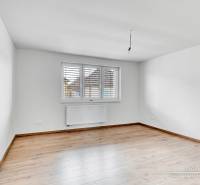 Szoba fehér falakkal és fa dekorációjú padlóval egy családi házban.