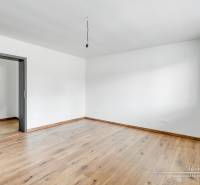 Szoba fehér falakkal és fa dekorációjú padlóval egy családi házban.