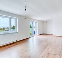 Tágas nappali családi házban, fa dekorációjú padlóval és nagy ablakokkal.