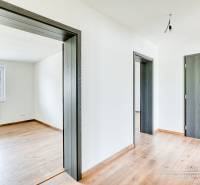 Családi ház fa dekor padlóval, ajtókkal és fehér falakkal.