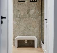 Előszoba padokkal, akasztókkal és fa dekorációjú padlóval egy kétszobás lakásban.