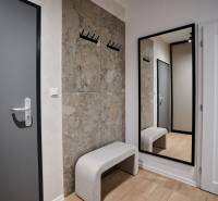 Előszoba egy kétszobás lakásban fogassal, tükörrel és fa dekorációjú padlóval.