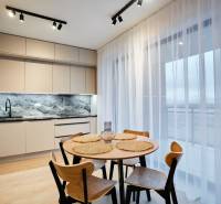 Konyha egy kétszobás lakásban fa dekor padlóval és étkezőasztallal.