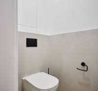 Fürdőszoba egy kétszobás lakásban minimalista dizájnnal és falra szerelt WC-vel.