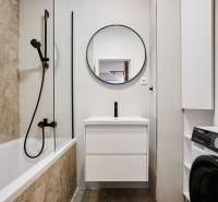 Fürdőszoba káddal, zuhanyzóval és mosógéppel egy kétszobás lakásban.