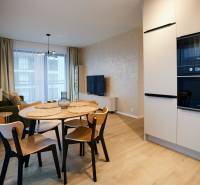 Nappali egy kétszobás lakásban, fa dekoros padlóval és étkezőasztallal.