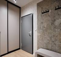 2 szobás lakás előszobája fa dekor padlóval és gardróbszekrénnyel.