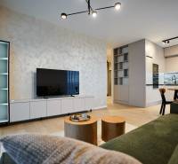 Nappali egy kétszobás lakásban fa dekor padlóval és modern konyhával.