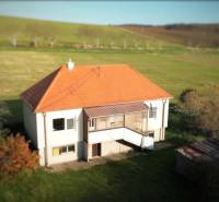 Családi ház Dobra Vodán ferde tetővel, zölddel és rétekkel körülvéve.