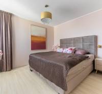 Hálószoba családi házban, ággyal, képpel, lámpával és fa dekorációjú padlóval.