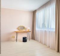 Világos szoba családi házban fésülködőasztallal, arany tükörrel és fa dekoros padlóval.