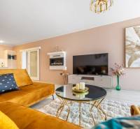 Nappali dekoratív festménnyel, kanapéval és asztallal egy családi házban.