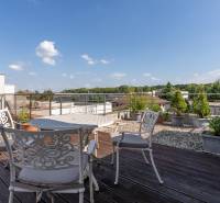 A Jazdecká utcai családi ház terasza Nagyszombatban virágtartókkal és ülőgarnitúrával.