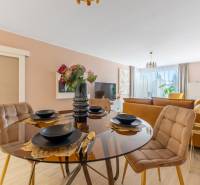 Egy étkezőasztal terítékkel, a háttérben egy családi ház nappalija.