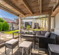 A Jazdecká utcai családi ház terasza Trnavában rattan bútorokkal és rejtett medencével.