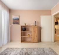 Családi ház belső tere fa dekor padlóval, szekrénnyel és függönyökkel.