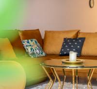 Családi ház kanapéval, asztallal gyertyával és díszpárnákkal.