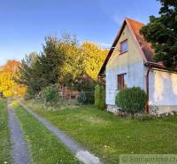 Kunyhó az útonál, Sološnicán, fákkal és gyepes területtel körülvéve ősszel.