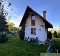 Ház Sološnicában rendezett kerttel, fákkal körülvéve és tiszta égbolttal.