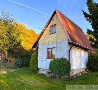 Ház Sološnicában, zölddel körülvéve, nyeregtetővel és gondozott gyepfelülettel.