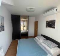 Hálószoba egy háromszobás lakásban ággyal, légkondicionálóval és beépített szekrénnyel.