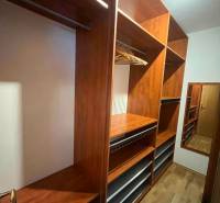 Fa ruhásszekrény polcokkal és tükörrel egy háromszobás lakásban.